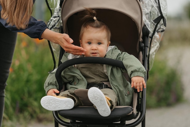 A female toddler is sitting in the stroller on a cloudy day