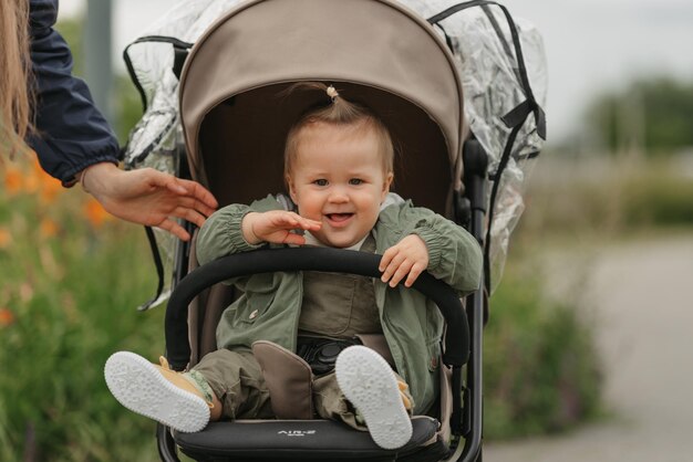 A female toddler is sitting in the stroller on a cloudy day