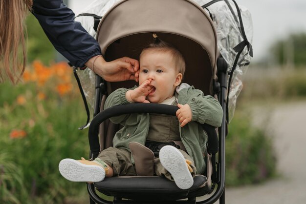 A female toddler is sitting in the stroller on a cloudy day