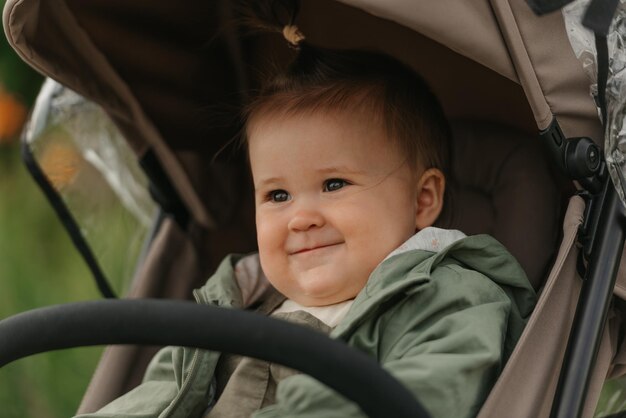 A female toddler is sitting in the stroller on a cloudy day