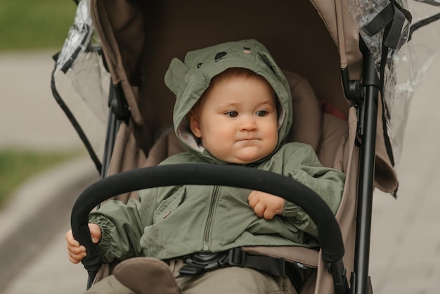 A female toddler is sitting in the stroller on a cloudy day