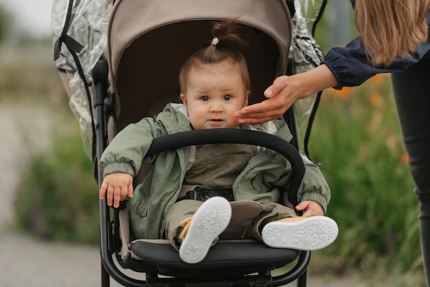 A female toddler is sitting in the stroller on a cloudy day