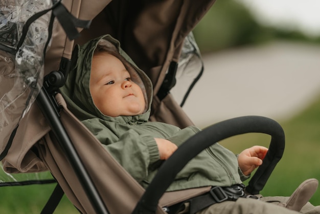 A female toddler is sitting in the stroller on a cloudy day