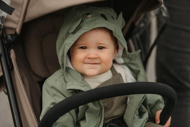 A female toddler is sitting in the stroller on a cloudy day