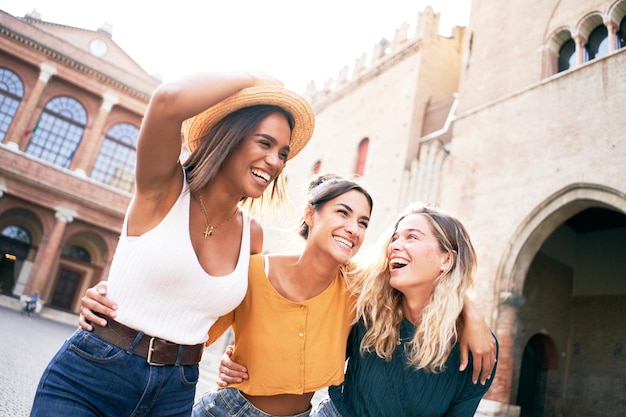 Туристка в городе на летних каникулах три счастливые молодые женщины наслаждаются отдыхом на открытом воздухе в