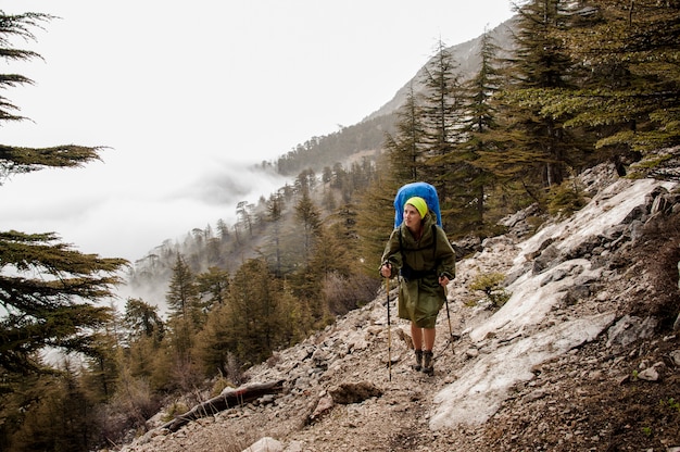 Female tourist goes down the mountain in forest