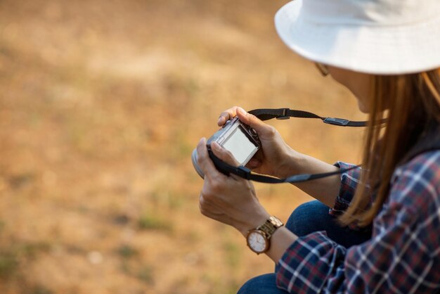 Foto una turista donna si siede felice e guarda la telecamera che ha preso da sola