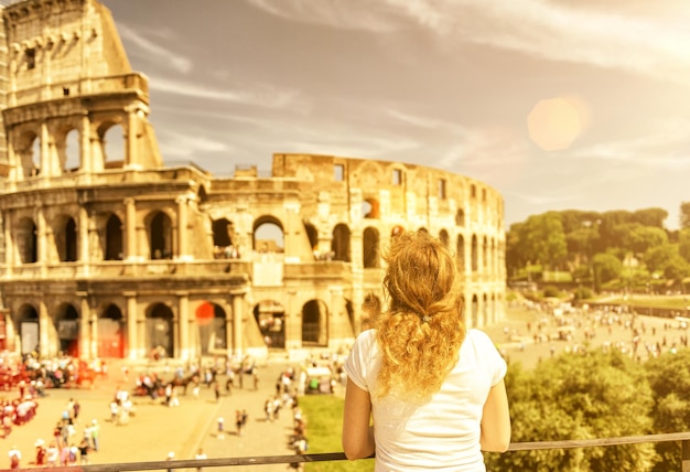 The female tourist looks at the colosseum in rome