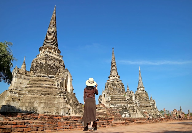Женщина-туристка посещает руины пагоды храма Ват Пхра Си Санпхет в историческом парке Аюттхая, Таиланд