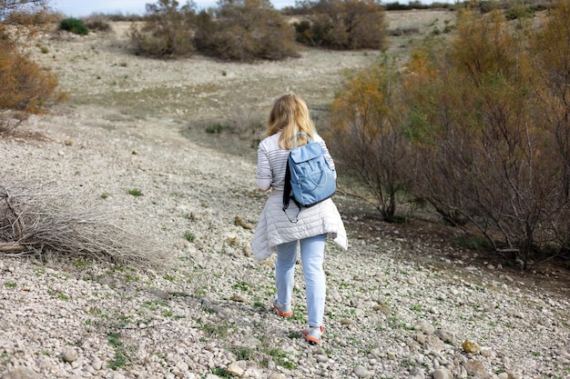 A female tourist walks along a mountain road