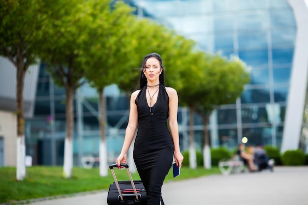 Female traveler walking with their luggage near airport