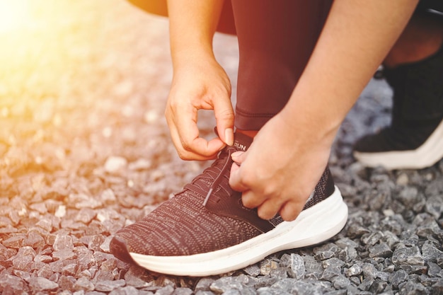 Female tying running shoes Preparing for a run a jog outside