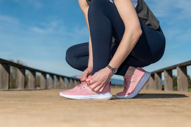 Photo female tying up laces on running shoes preperation before jogging