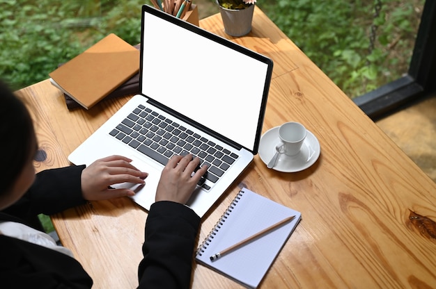 흰색 화면으로 노트북 컴퓨터에 입력하는 여성