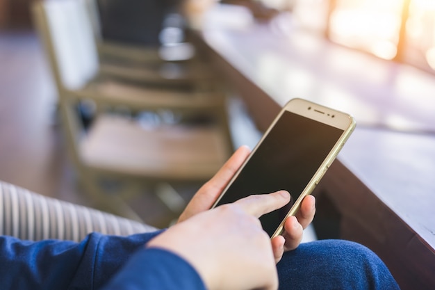 female use cell phones blurred images in coffee shop like the background.