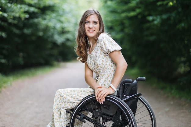 Женщина-пользователь инвалидной коляски отдыхает в одиночестве в парке
