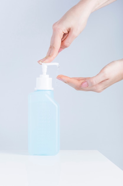 Female using hand press bottle and pouring sanitizer on other hand