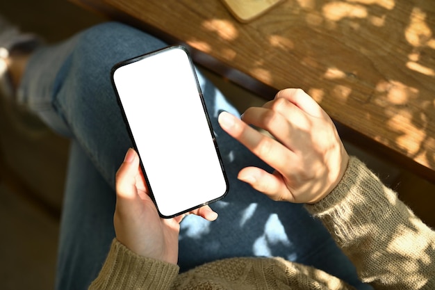 A female using her smartphone while relaxing at a table in a beautiful minimal cafe