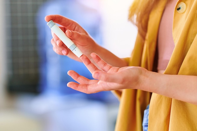 혈당 수치를 측정하고 확인하기 위해 손가락에 랜서를 사용하는 여성 건강 및 진성 당뇨병 치료