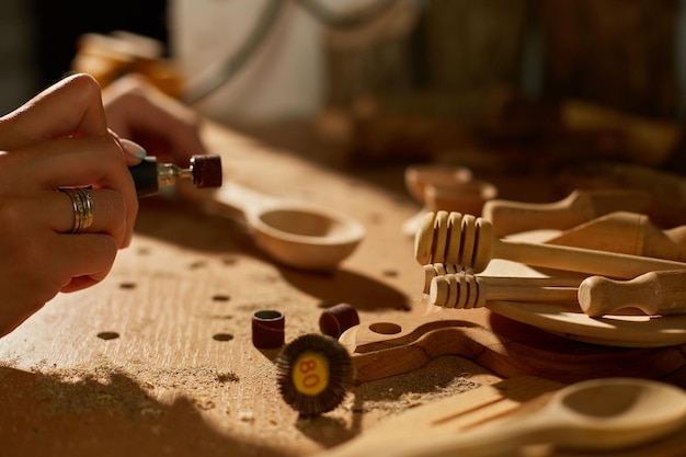 Female using power working tools graver for wooden utensils spoon