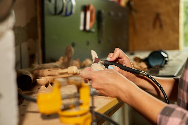 Женщина, использующая электроинструменты, гравер для деревянной посуды, ложка