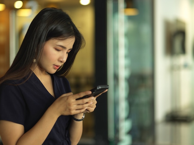 female using smartphone while relaxing in office room