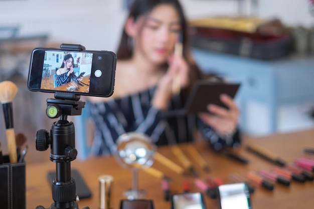 Foto vlogger femminile che si trucca sullo schermo del cellulare