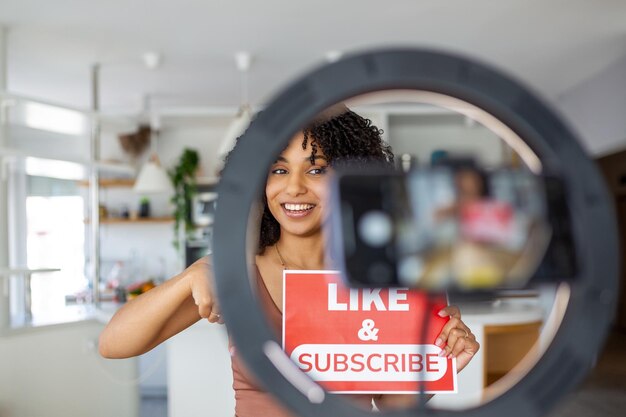 女性のVloggerがオンライン視聴者に彼女のチャンネルの日々のビデオを好み,サブスクリプションするよう求めています.