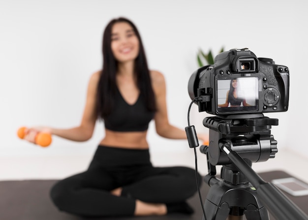 Female vlogger at home with camera exercising