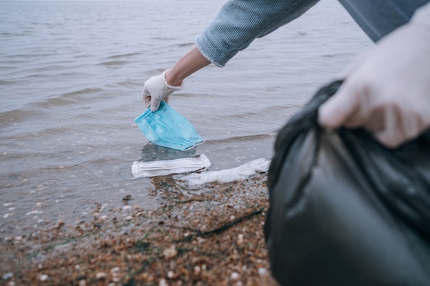 Female volunteer removing medical mask from the water