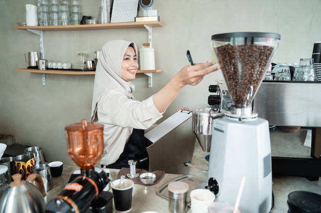 Female waiter holds a machine coffee