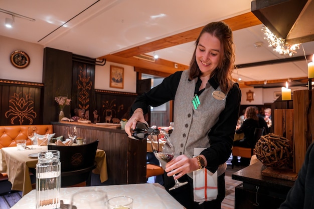 Female waitress pours wine at inviting restaurant table