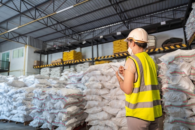 Работница склада принимает к сведению количество химикатов в квасцах или на складе химикатов Концепция международного экспортного бизнеса