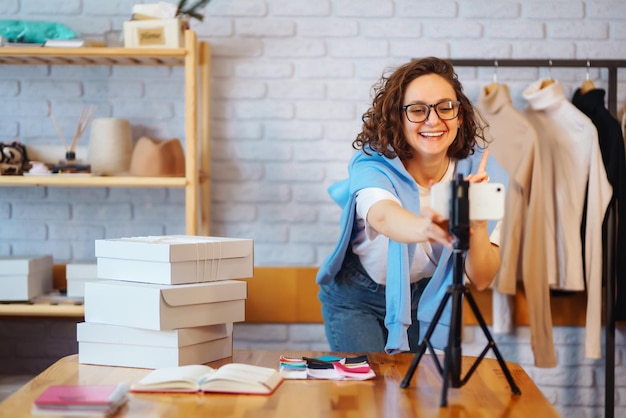 Female warehouse worker seller dropshipping small business owner recording new content for vlog