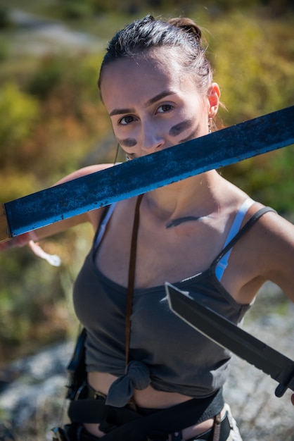 Female warrioir posing with machete at outdoor. summer lifestyle