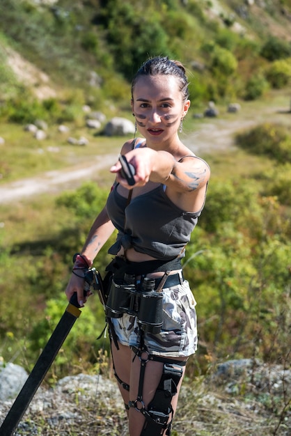 Female warrioir posing with machete at outdoor. summer lifestyle