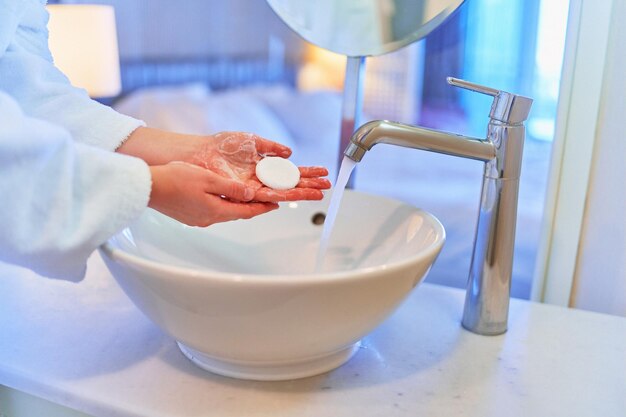 Female washing her hands in cozy bathroom