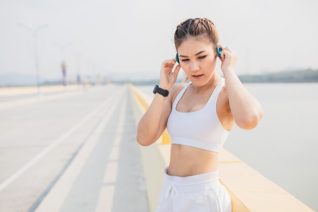 Photo female wearing headphones runners jogging cardio running endurance training slow motion shot of legs runner sneakers legs running run on street