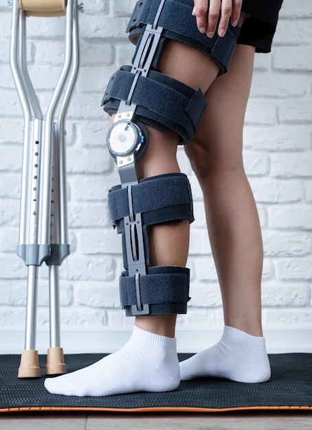 Female wearing knee orthosis or knee support brace after\
surgery on leg