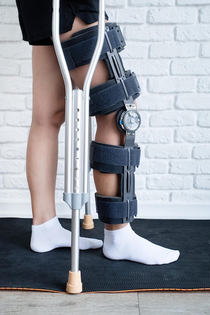 Female wearing knee orthosis or knee support brace after\
surgery on leg