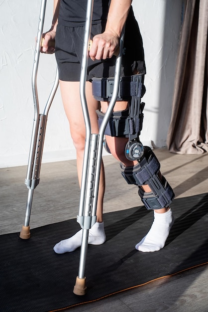 Female wearing knee orthosis or knee support brace after\
surgery on leg