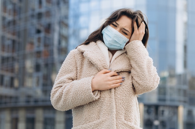 Female wearing medical protective mask outdoors. Health protection prevention during flu virus outbreak, coronavirus COVID-19 epidemic and infectious diseases in the city