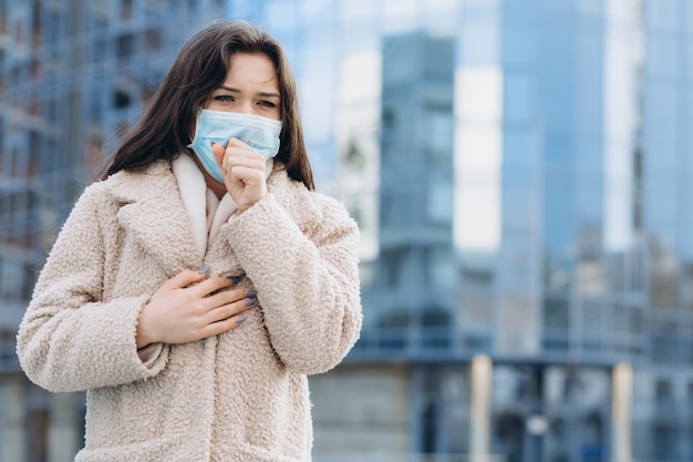 Female wearing medical protective mask outdoors.