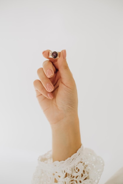 Female wearing wedding dress holding golden ring by hand