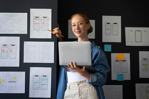 Foto web designer femminile in ufficio con il laptop