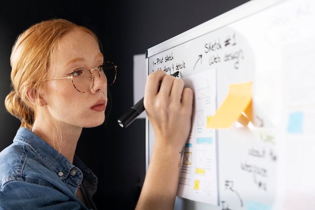 Photo female web designer with papers and notes in the office