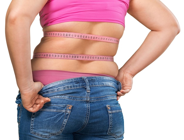 Female who has gained weight and can no longer fit into her jeans - isolated image