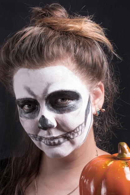 Photo a female witch with a pumpkin. scary halloween holiday