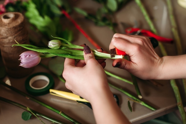 Female with flowers  above table with florist tools.