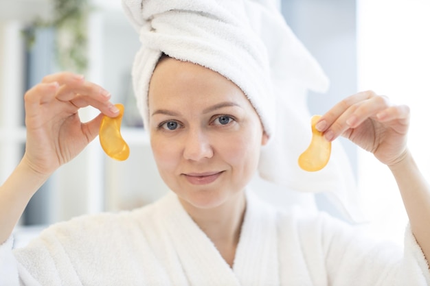 Female with gold eye gels relaxing after bath at home